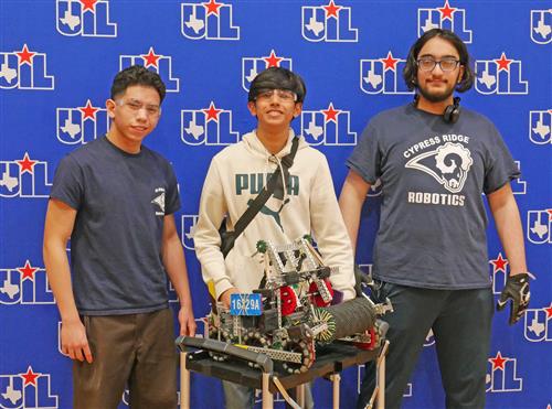 3 Cy Ridge HS robotics students with their robot
